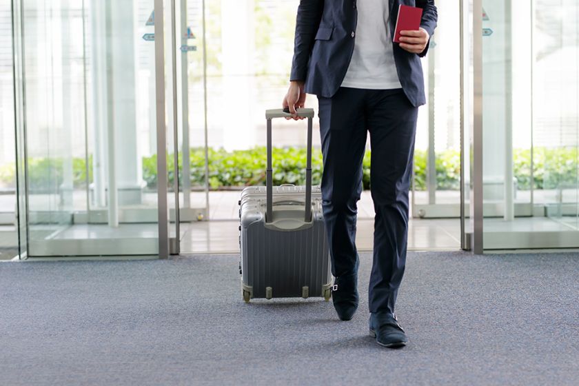 Foto: Mann mit Koffer am Flughafen